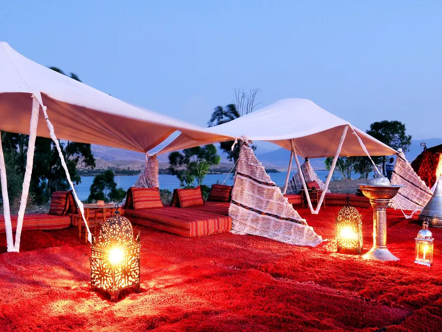 White tents and lanterns of a desert camp